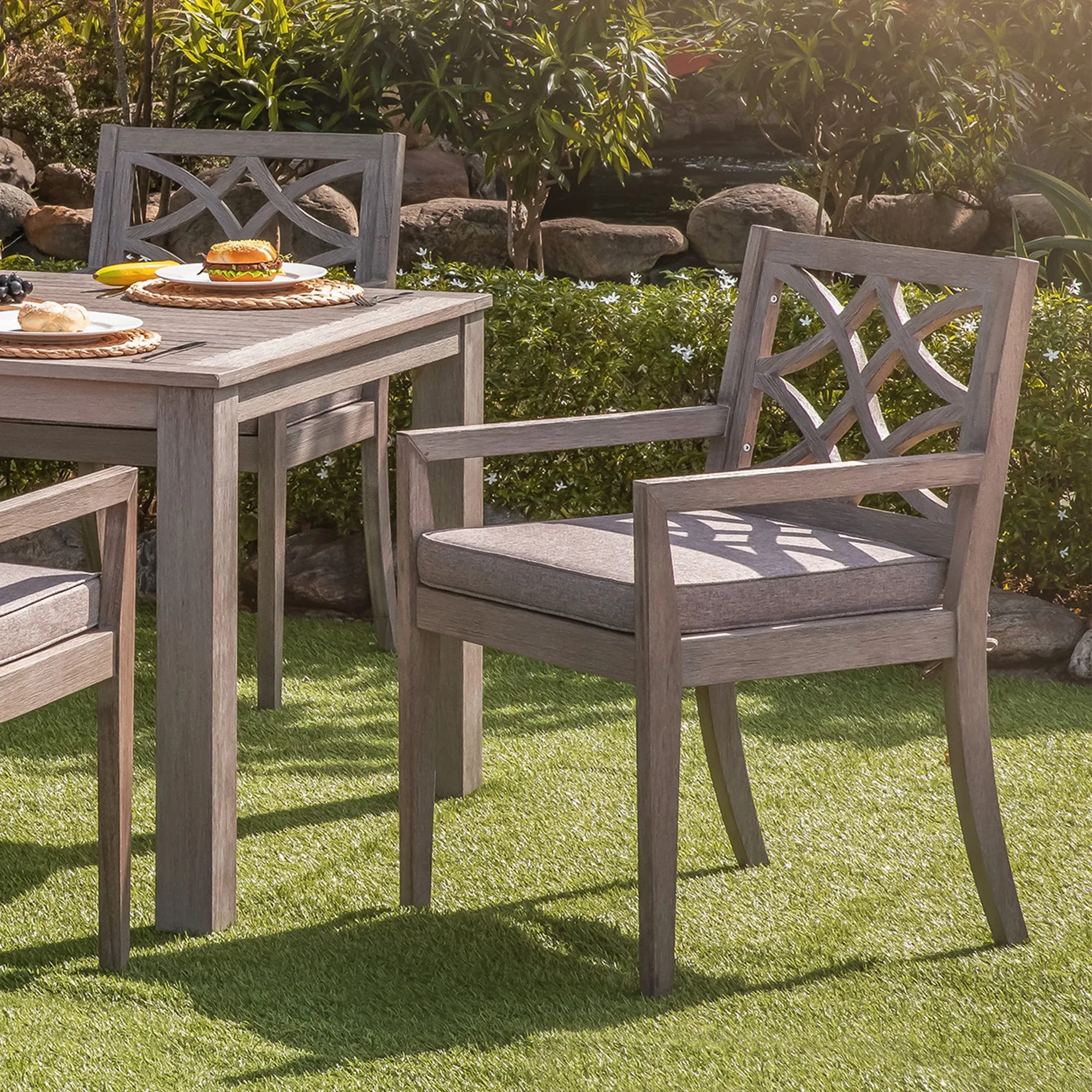 Gray eucalyptus patio dining chairs with cushions on a covered patio