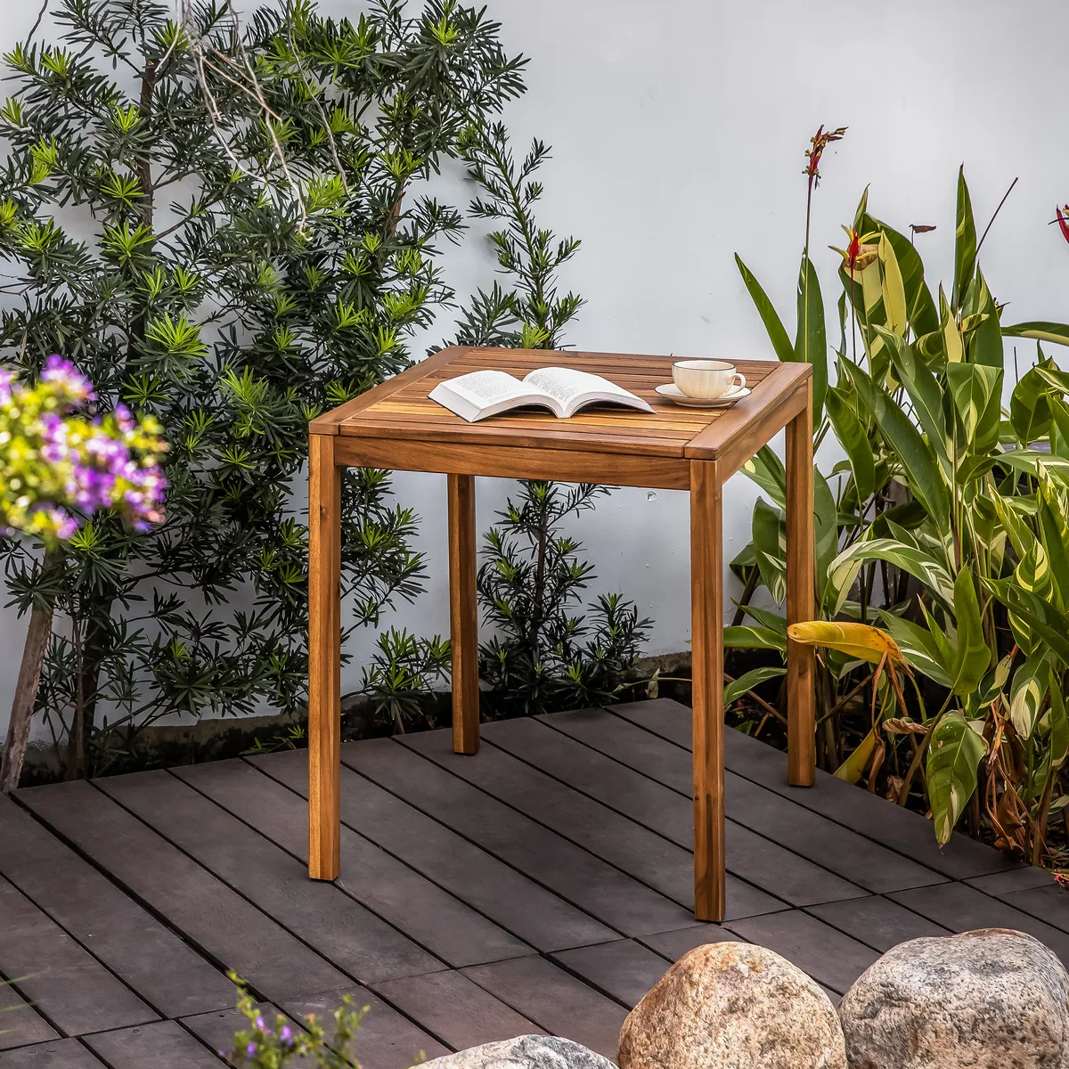Solid wood outdoor bistro table styled with a book and cup outdoors