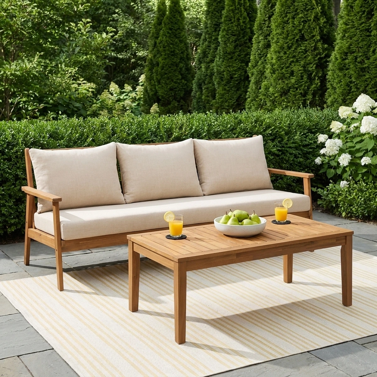 Acacia patio sofa styled with a throw in a sunny garden